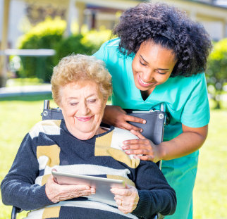 a female caregiver with an elderly woman with a tablet